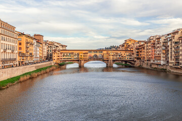 Naklejka premium Arno river leading to the famous bridge Ponte Vecchio at the beautiful evening in Florence, Italy