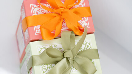 Pink gift box near the green box with bows for a celebration