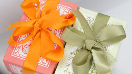 Pink gift box near the green box with bows for a celebration
