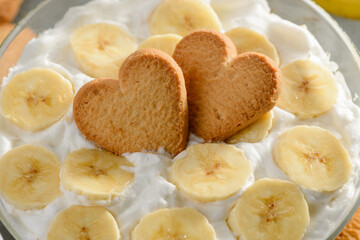 Heart cookies on a dessert top. Banana slices and whipped heavy cream