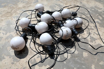 Old bulbs are arranged in different ways on the cement floor. 