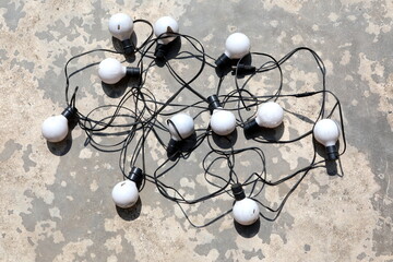 Old bulbs are arranged in different ways on the cement floor. 