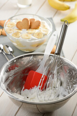 Metal bowl, whisk and silicone spatula after whipping cream