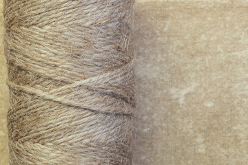 Twine rope jute linen in bobbins skeins close-up on a vintage background with copy space, household goods, production of rope products
