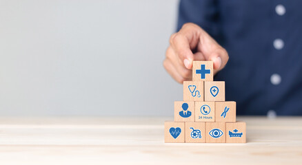 Hand arranging wood block stacking with icon healthcare medical, Health insurance - concept.