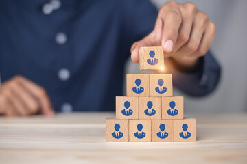 Concept of human resource management and recruitment business Hand put wood cube block on top pyramid To business success concept.