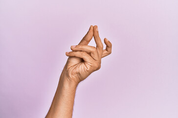 Arm and hand of caucasian young man over pink isolated background snapping fingers for success,...