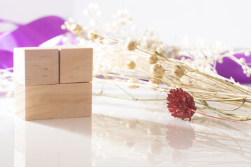 Obraz na płótnie Canvas Wooden cubes to put text together with preserved flowers and violet ribbon.