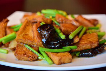Tofu fried with garlic arrows and black сhinese mushrooms.
