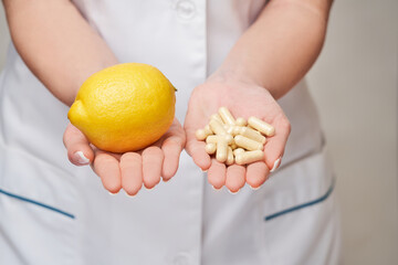nutritionist doctor healthy lifestyle concept - holding fresh organic lemon fruit and vitamin...