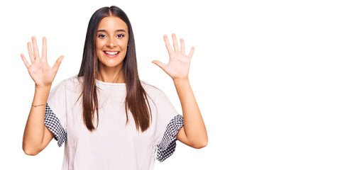 Obraz na płótnie Canvas Young hispanic woman wearing casual clothes showing and pointing up with fingers number ten while smiling confident and happy.