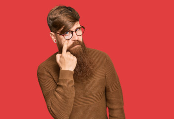 Young irish redhead man wearing casual clothes and glasses pointing to the eye watching you...