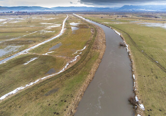 Flooded areas near Olt river in Romania, hungarian villages in the background, aerial view.