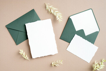 Elegant wedding stationery set. Wedding invitation card mockup, green envelopes, dried flowers on...