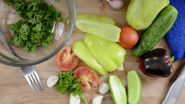 Salad preparation. Healthy salad vegetables. Fresh washed vegetables are on the table. Bulgarian pepper, cucumbers, garlic and tomatoes with herbs for dietary nutrition