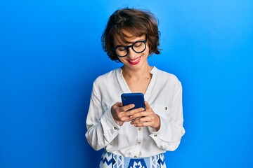 Young brunette woman using smartphone smiling with a happy and cool smile on face. showing teeth.