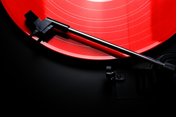 Red vinyl record spinning on a turntable - gramophone needle - directly above