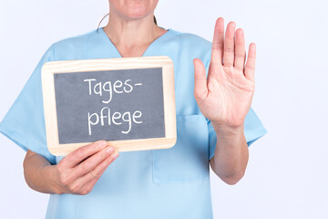Pflegekraft im Seniorenheim oder Krankenhaus mit einer Tafel Tagespflege