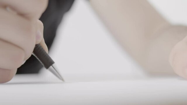 A hand is seen scribbling something on a large sheet of paper, most likely a technical concept of some kind. The camera is rotating around the drawer's hand in a half circle.