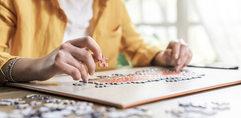 Woman sitting at desk and solving a puzzle
