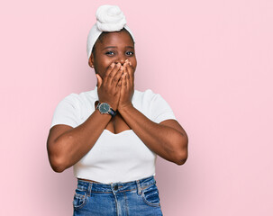 Young african woman with turban wearing hair turban over isolated background laughing and...