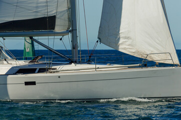 Fototapeta premium A modern sailboat sails in calm ocean on a sunny day. No land in sight