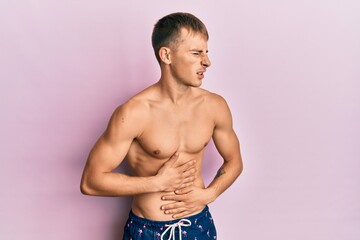 Fototapeta premium Young caucasian man wearing swimwear with hand on stomach because nausea, painful disease feeling unwell. ache concept.