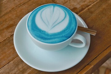 Closeup blue latte art on wood table