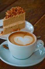 Hot latte art coffee with coffee cake background