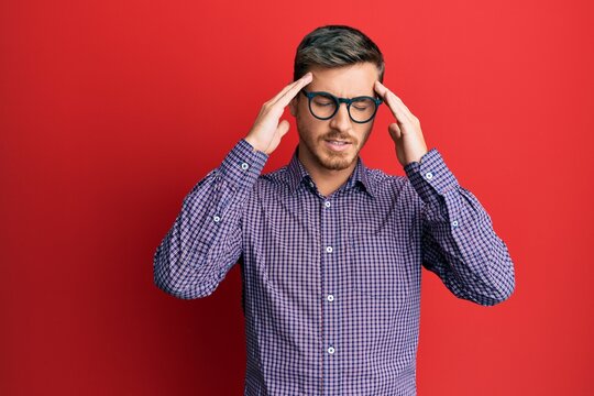 Handsome caucasian man wearing business shirt and glasses with hand on head, headache because stress. suffering migraine.