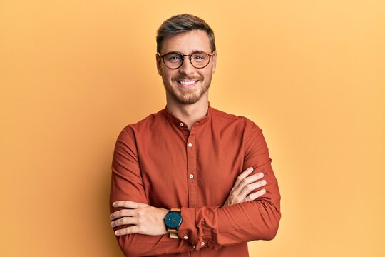 Handsome caucasian man wearing casual clothes and glasses happy face smiling with crossed arms looking at the camera. positive person.