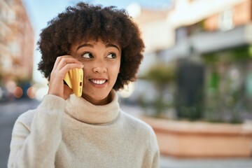 Young hispanic girl smiling happy talking on the smartphone at the city.