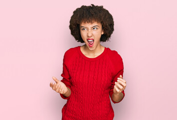 Young hispanic girl wearing casual clothes crazy and mad shouting and yelling with aggressive...