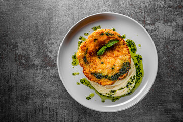 schnitzel with mashed potatoes and pesto sauce on plate