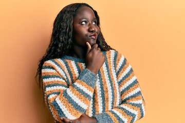 African young woman wearing wool winter sweater serious face thinking about question with hand on...
