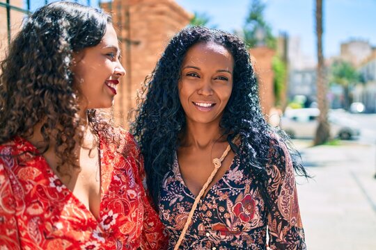 African american mother and daughter smiling happy hugging at the park.