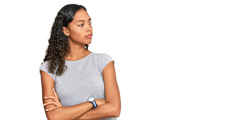 Young african american girl wearing casual clothes looking to the side with arms crossed convinced and confident