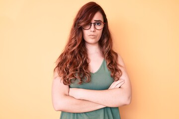 Young beautiful woman wearing casual clothes and glasses skeptic and nervous, disapproving...