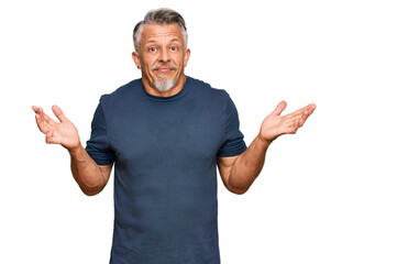 Middle age grey-haired man wearing casual clothes clueless and confused expression with arms and hands raised. doubt concept.