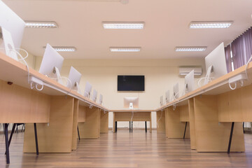 Modern office with computers on desks. Empty computer room in college. Interior of classroom with computers. Concept of corporate working space.