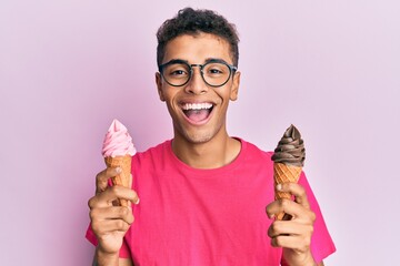 Young handsome african american man holding ice cream cones smiling and laughing hard out loud...