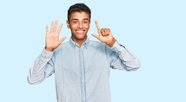 Young handsome african american man wearing casual clothes showing and pointing up with fingers number seven while smiling confident and happy.