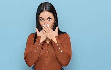 Young hispanic woman wearing casual clothes shocked covering mouth with hands for mistake. secret...