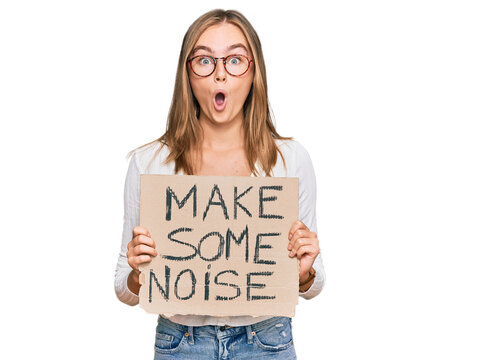 Beautiful blonde woman holding make some noise banner scared and amazed with open mouth for surprise, disbelief face