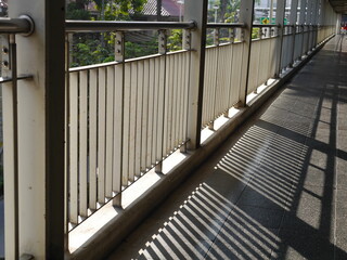 Light and shadow of the railing of the bridge in the daytime.