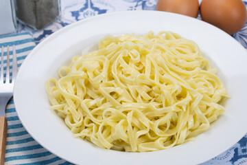 assiette de tagliatelles fraîches au beurre sur une table