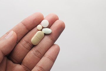 Close up of man hand holding pills with copy space 