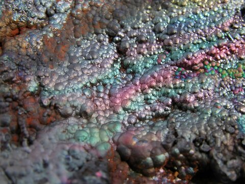 Looking down at the rainbow colours of botryoidal or globe shape crystals of goethite.
 Collectable mineral specimen of the iron ore familiy.