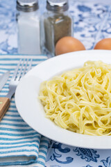 assiette de tagliatelles fraîches au beurre sur une table