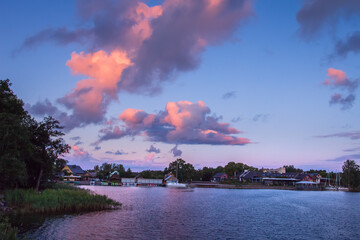 Fototapeta premium Pink cloudscape over the lake in the summer morning. Amazing scene of colorful sky in countryside lake